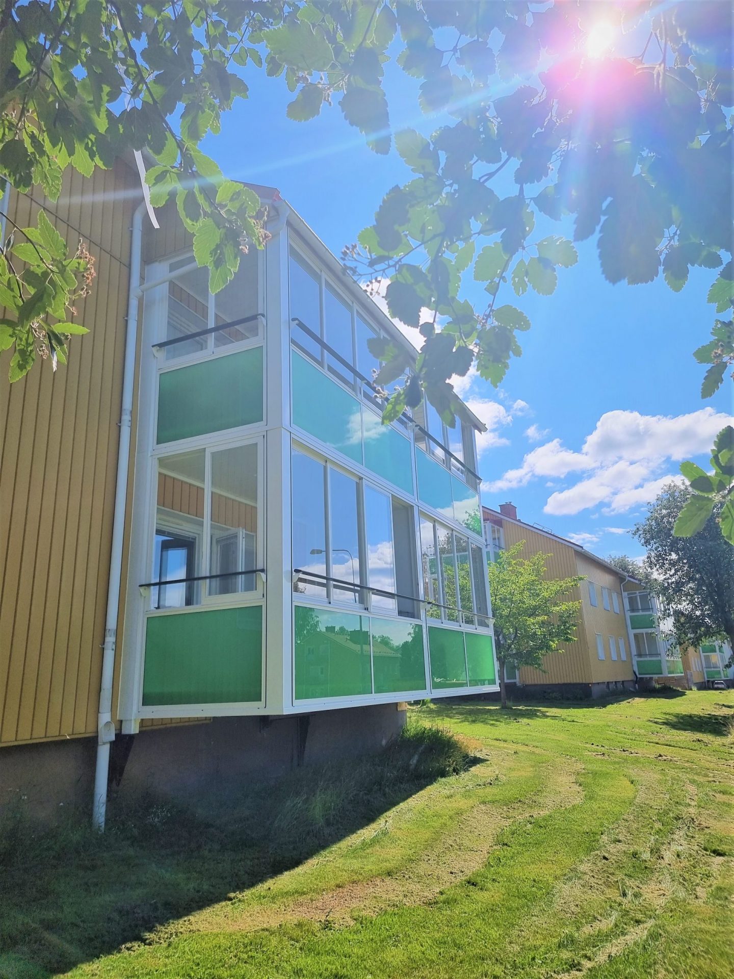 Gula hus med gröna balkonger